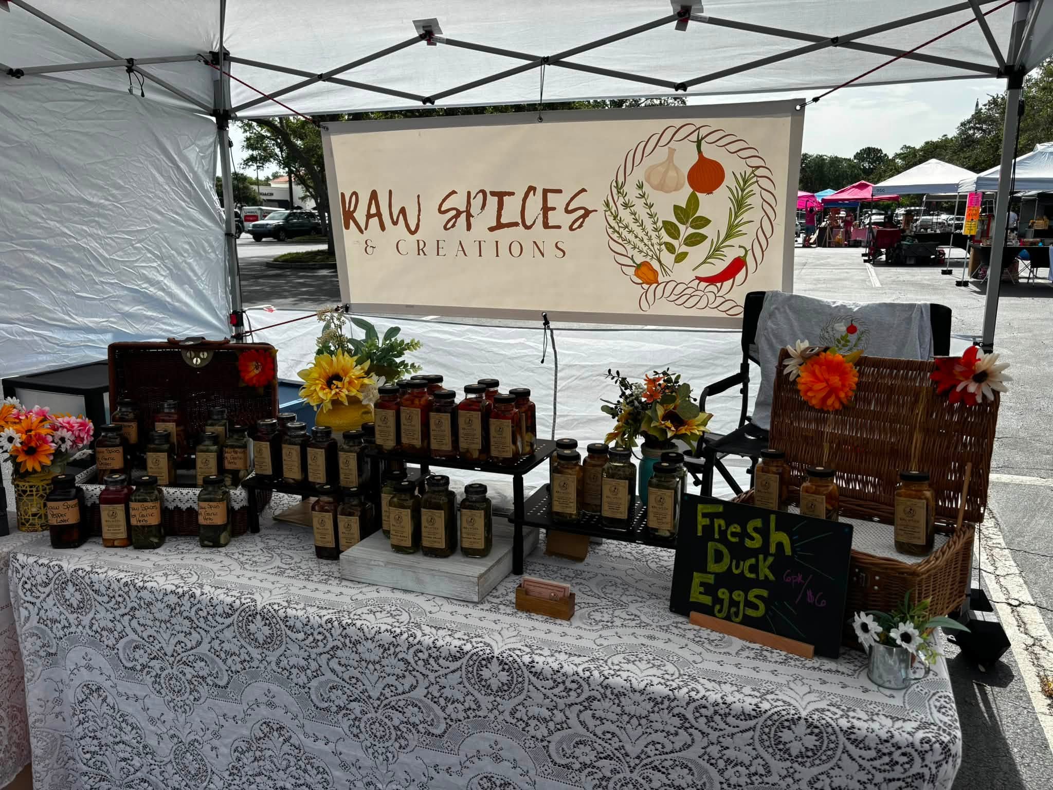 Raw Spices and Creations farmers market booth with handcrafted spice blends and flavored vinegars